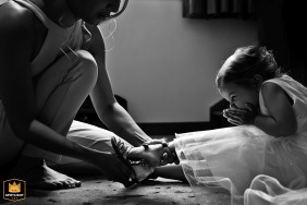 Novia en Chateauroux, riendo mientras ayuda a su hija con sus zapatos de boda, creando un momento conmovedor de amor y alegría.